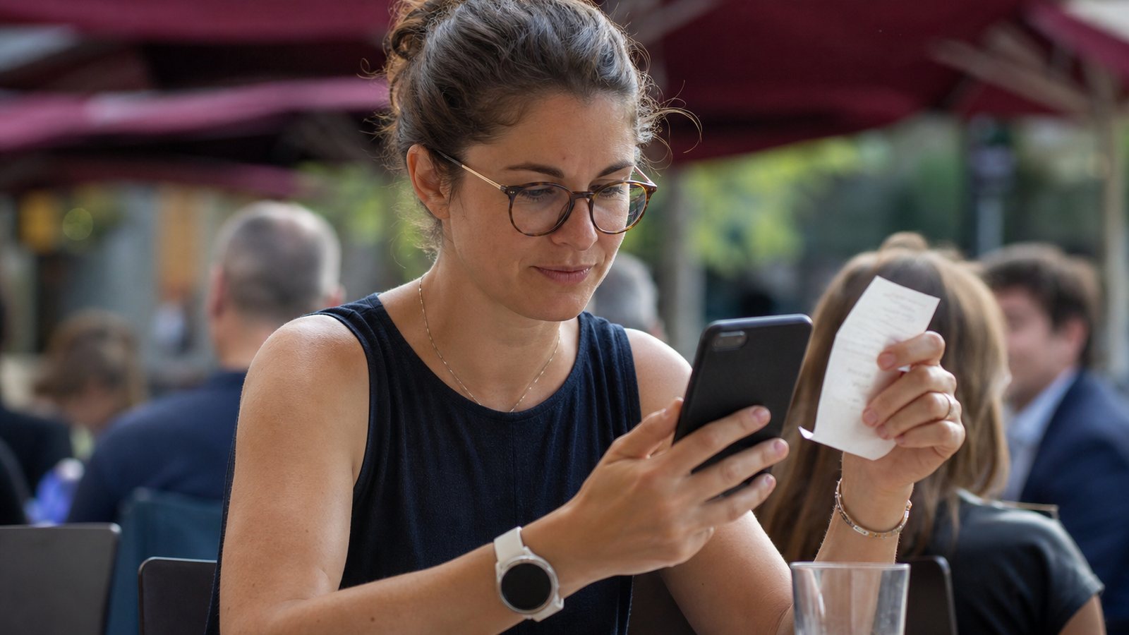 Main photographiant un reçu avec un smartphone pour créer une note de frais